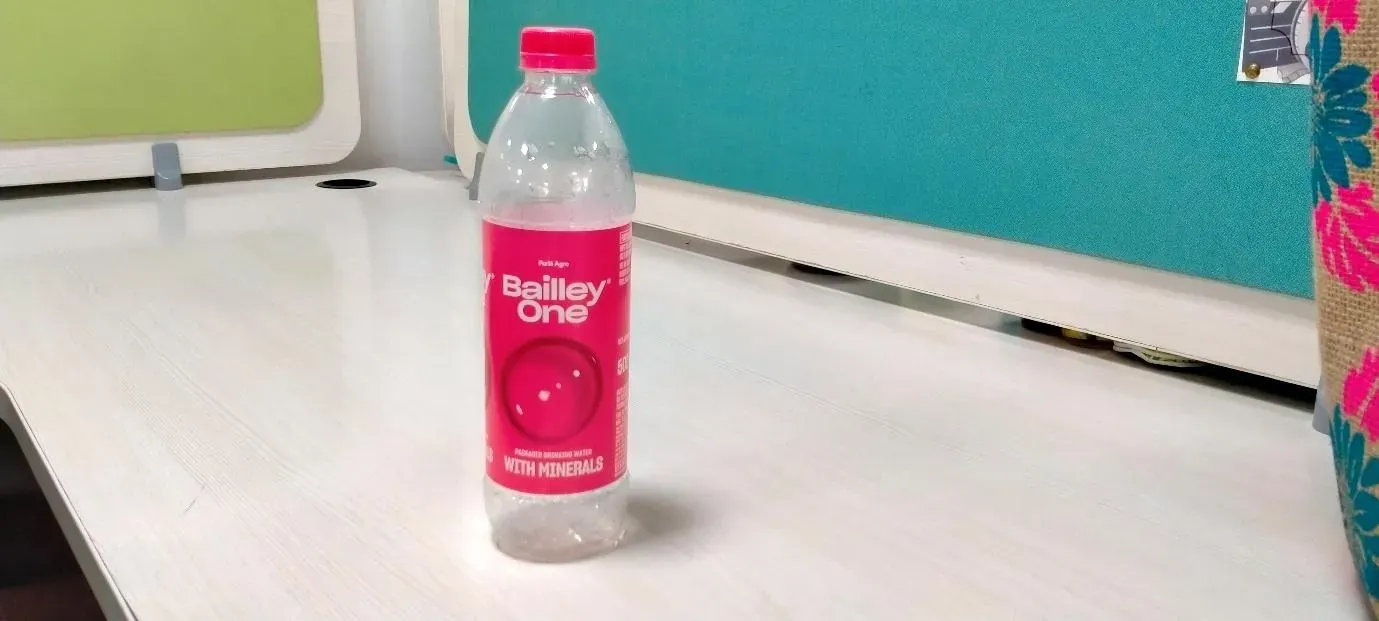 A bottle of water on a white surface

Description automatically generated